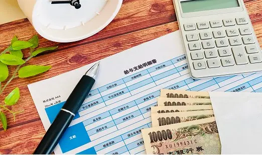 資料の上にあるお札と電卓