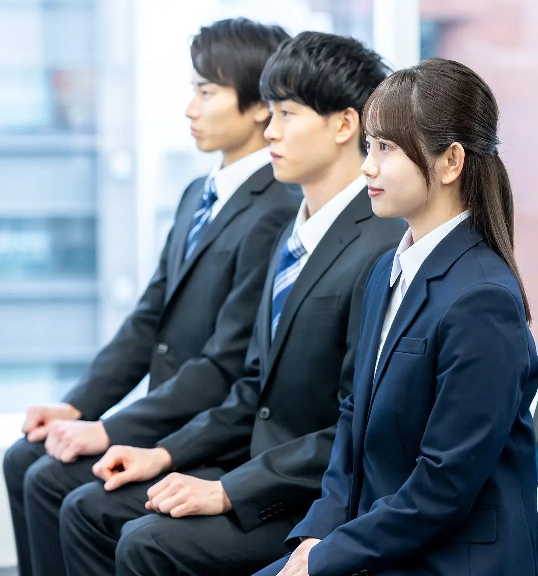 話を聞いているスーツ姿の３人